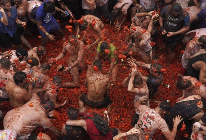 Revelers hurl tomatoes at each other and streets awash in red pulp in Spanish town's Tomatina party